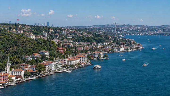 Bosfor sahili boyunca yaşayış binaları, gəmilər və uzaqda asma körpü